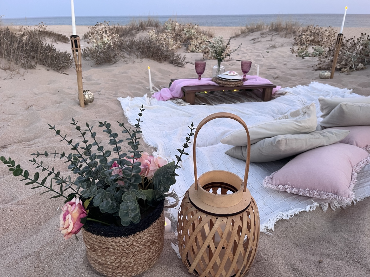 Pink and white picnic beside coastal dunes
