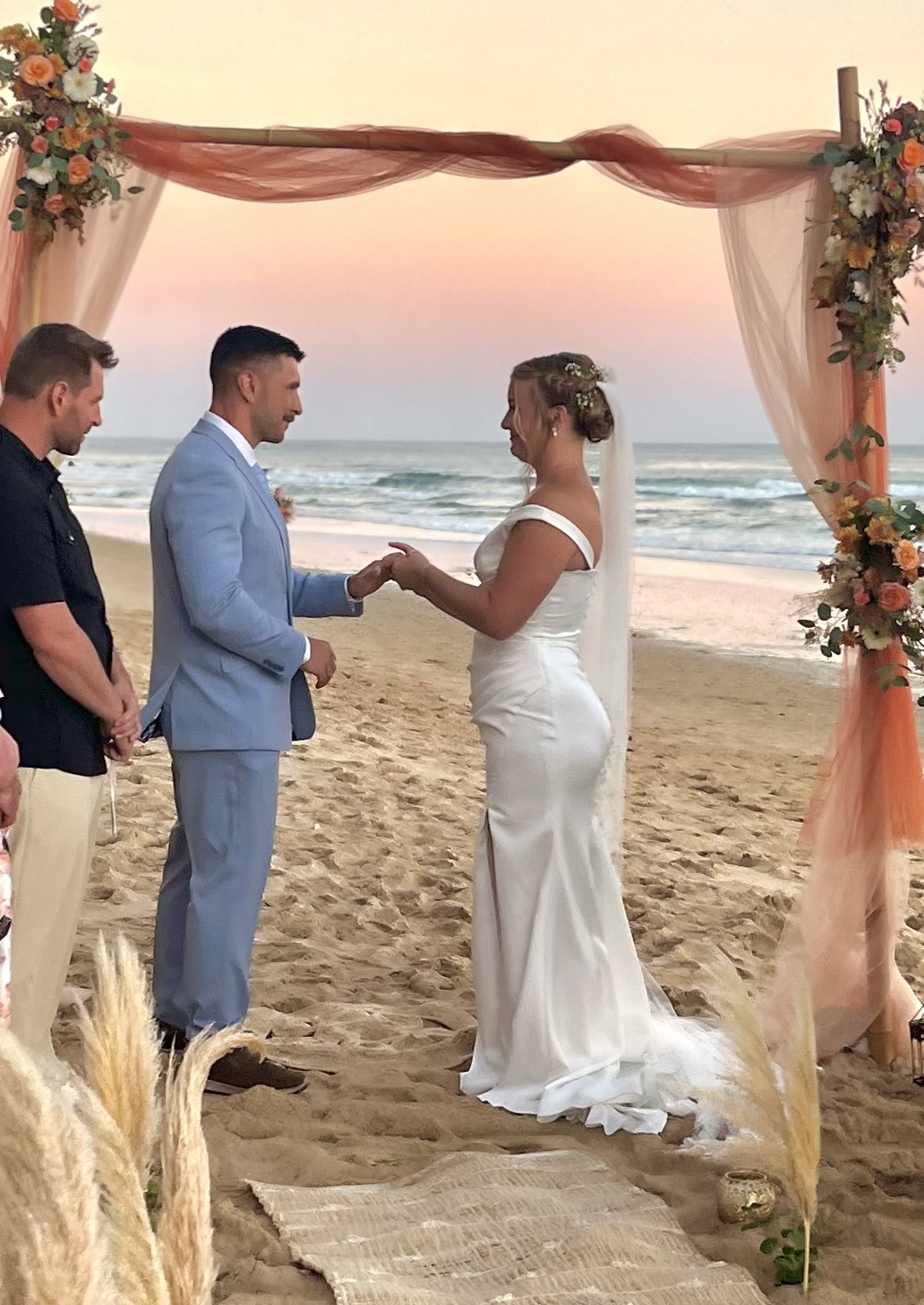 Casal numa cerimónia sob um arco com flores